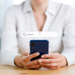 Businesswoman touching on smartphone for input wording and searching from web browser
