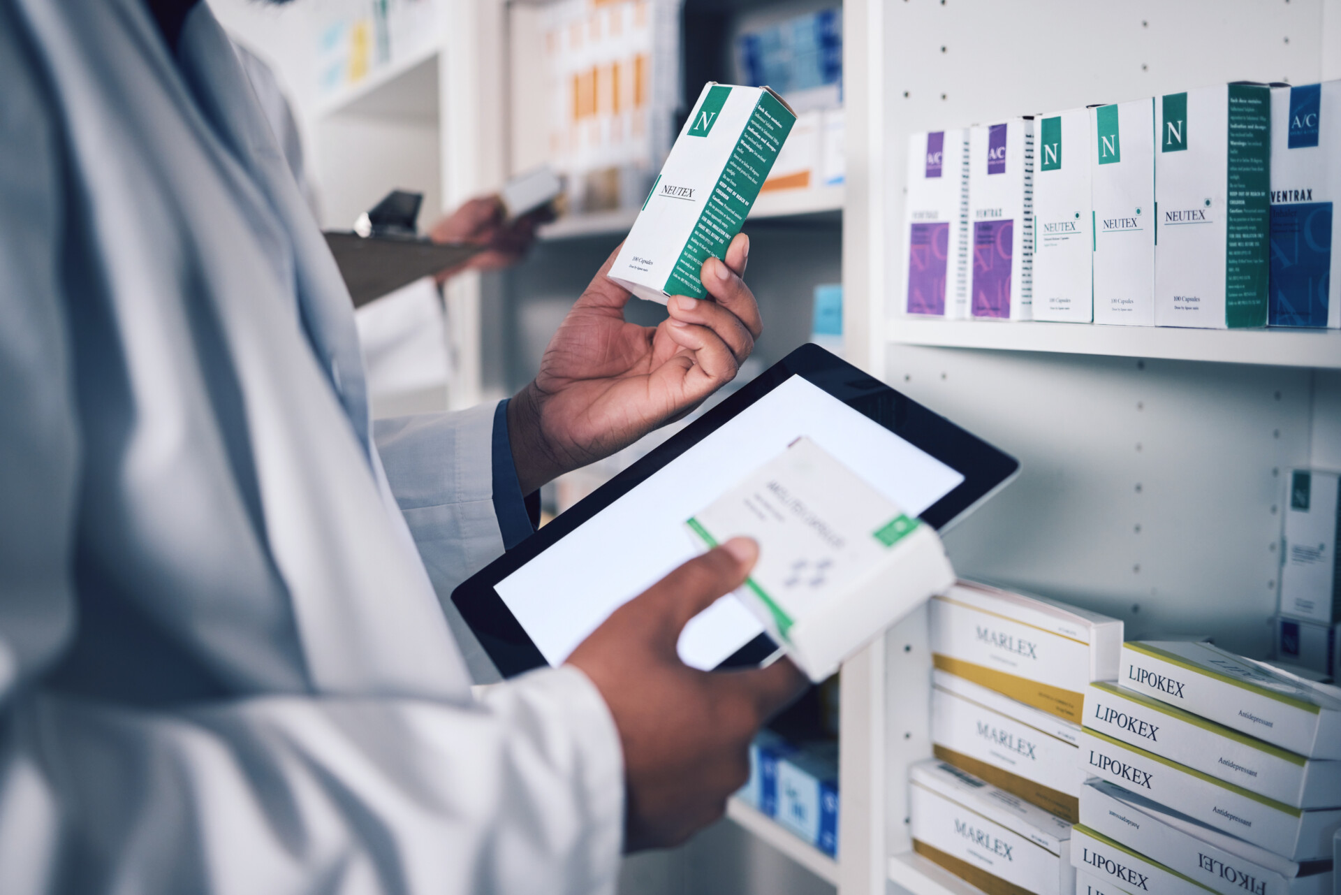 Pharmacist, tablet and hands for inventory inspection, box or medication on shelf at the pharmacy. Man, medical or healthcare professional checking stock, pills or medicine for storage at drugstore